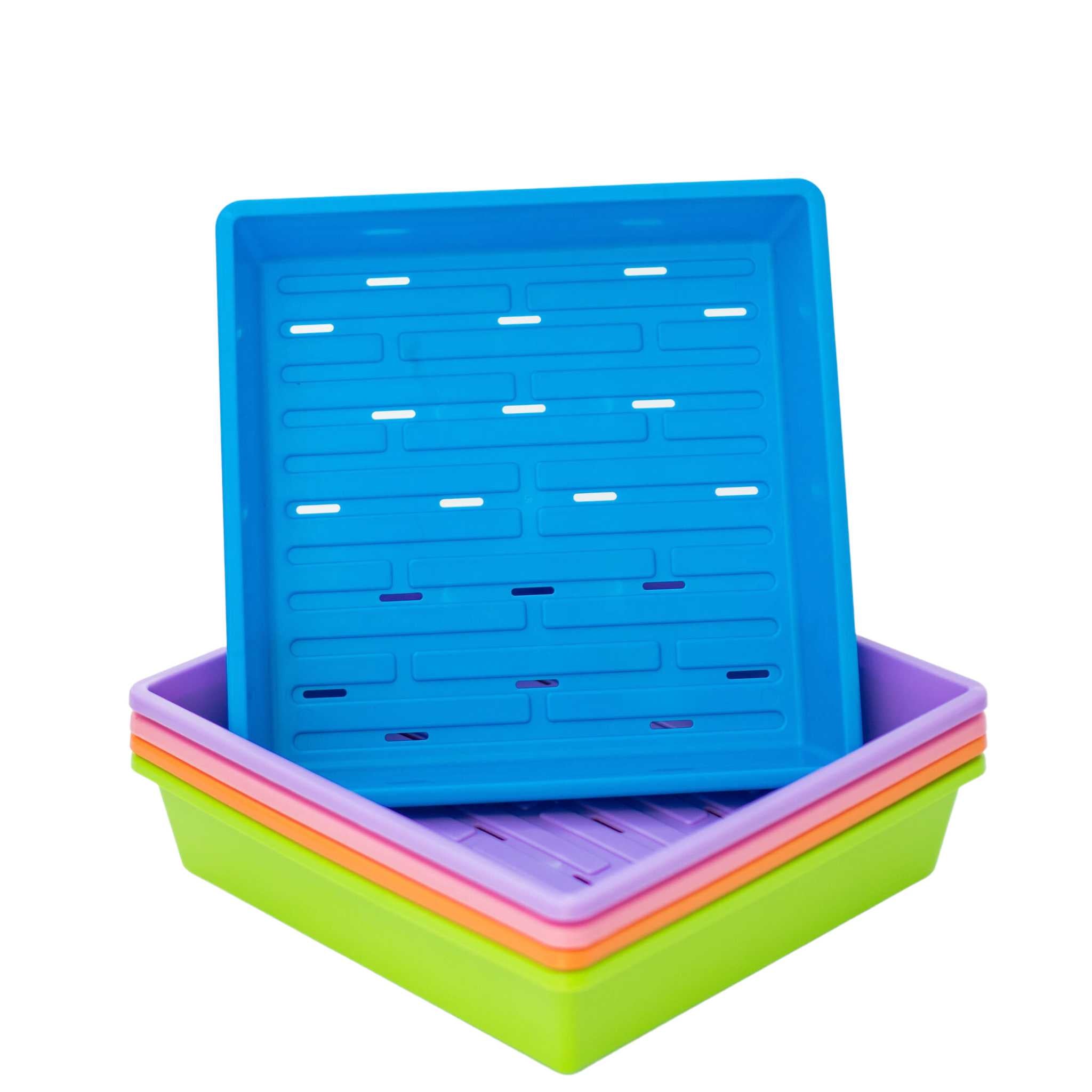 Blue plastic seed tray stacked on other colored trays on a white background