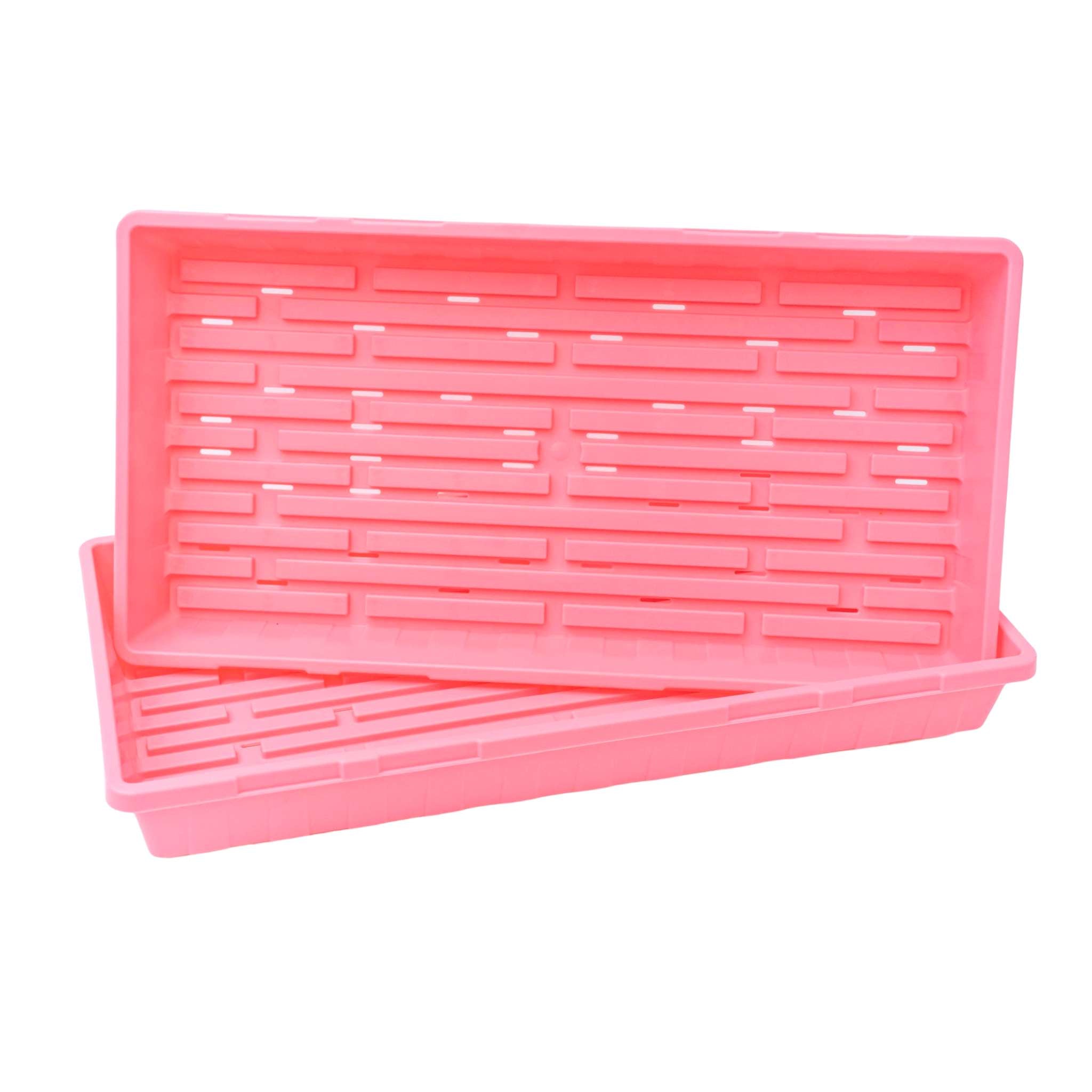 Two pink plastic trays with drainage holes on a white background