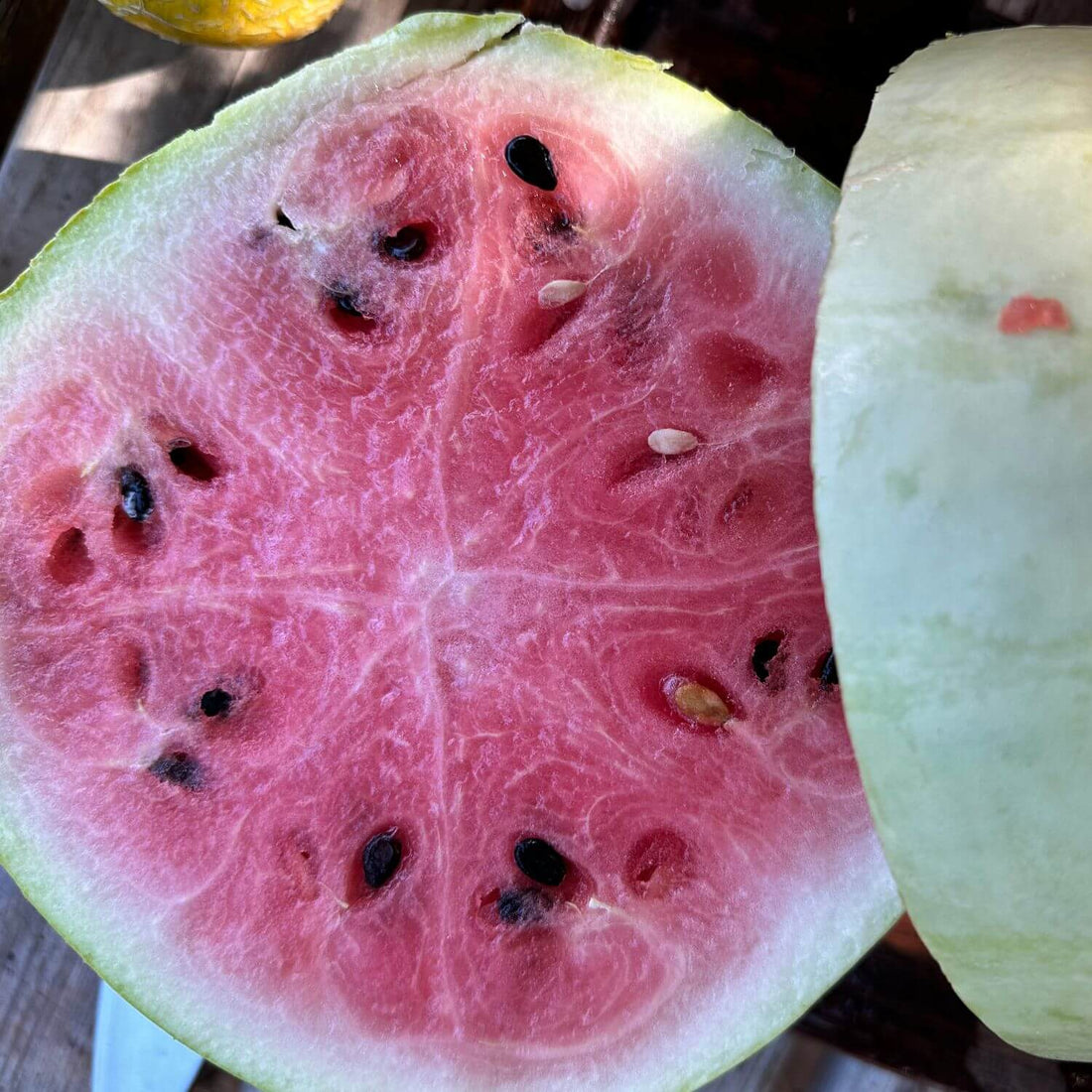 Close-up of a halved watermelon with pink flesh and green rind.
