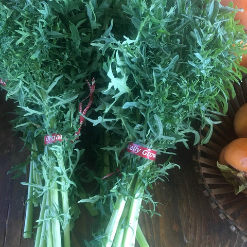 Bunches of green leafy Siber frill kale with 'Gally Grow' tags on a wooden surface.